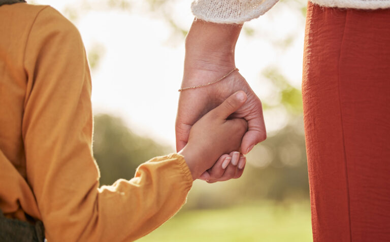 Adult and child hands clasped